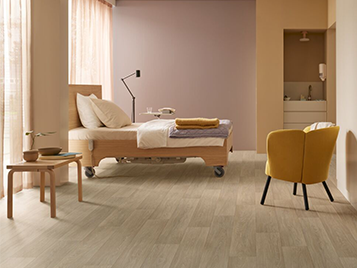 Forbo safety vinyl flooring in a residential care bedroom, showing warm tones and seamless installation