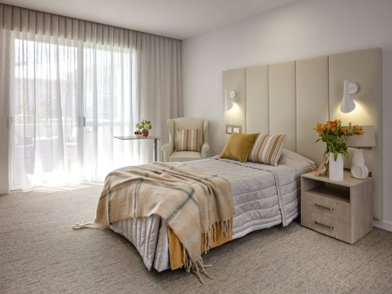 Interface carpet tiles in warm neutral tones installed in an aged care bedroom at Arcare, demonstrating dementia-friendly colour choices that create a calm, home-like atmosphere